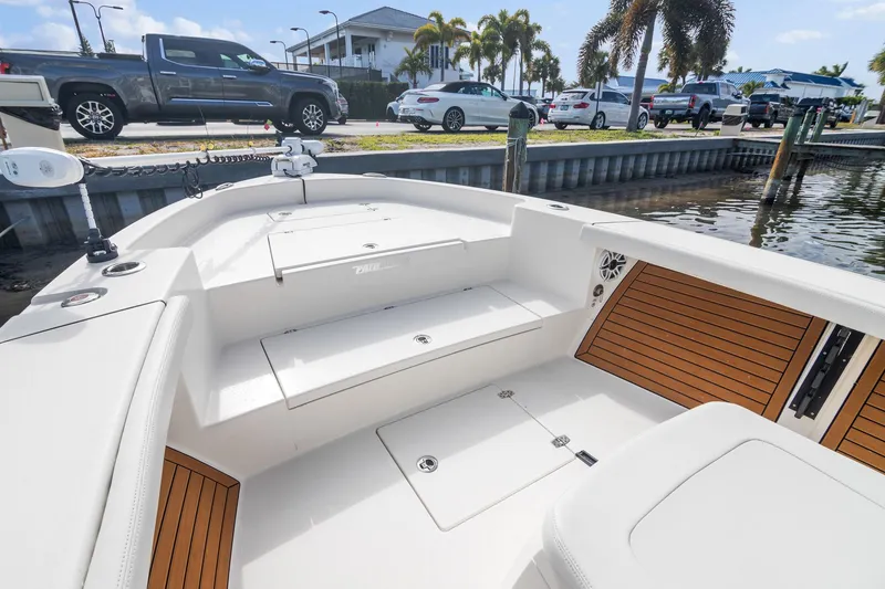 Slide: The Image of 2023 Pathfinder 2700 Open boat interior with seating and storage, docked near waterfront. - 10