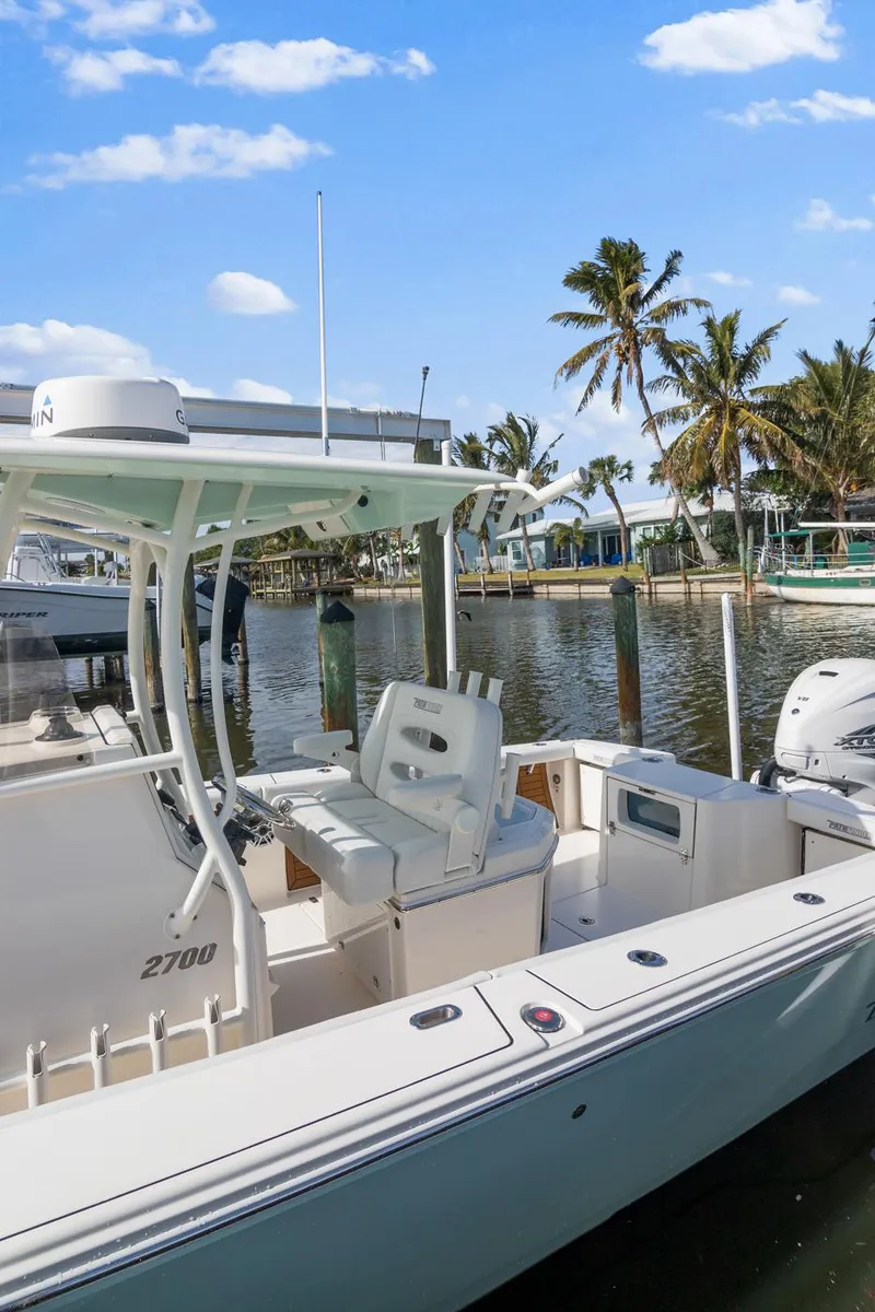 Slide: The Image of 2023 Pathfinder 2700 Open boat docked by palm trees under a clear blue sky. - 14