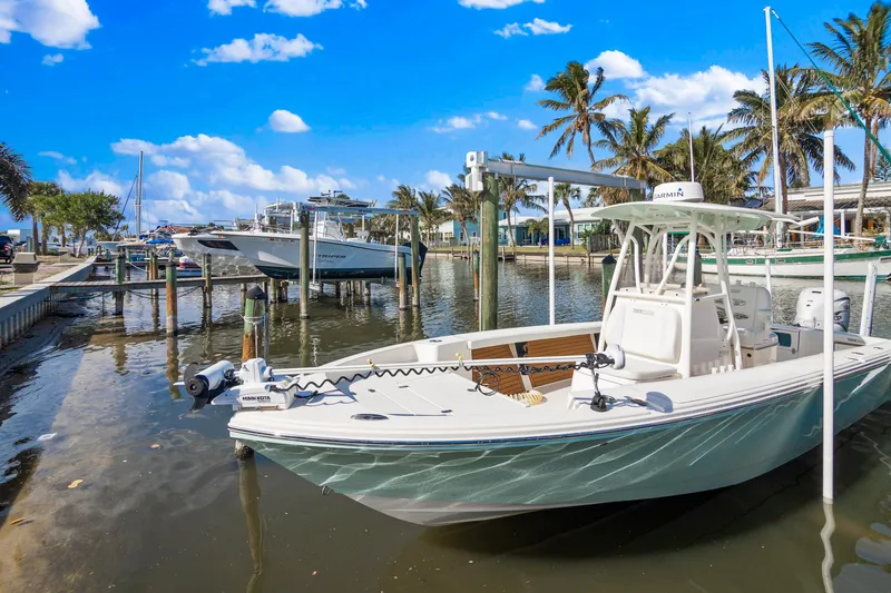 Slide: The Image of 2023 Pathfinder 2700 Open boat docked in a sunny marina with palm trees. - 4