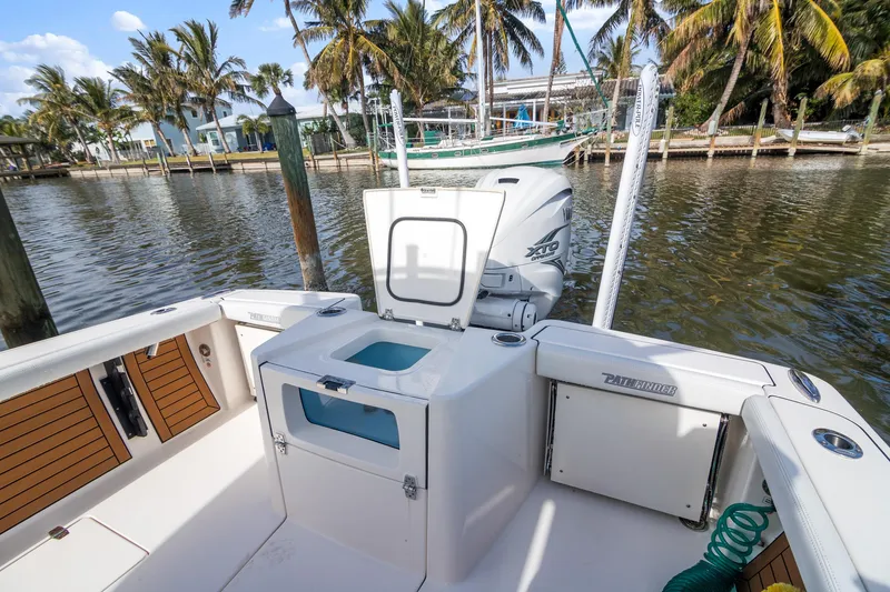 Slide: The Image of 2023 Pathfinder 2700 Open boat docked by palm trees, featuring spacious deck and storage compartments. - 8