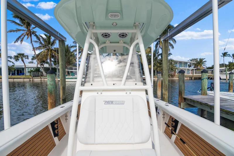 Slide: The Image of 2023 Pathfinder 2700 Open boat docked by palm trees and waterfront homes. - 9