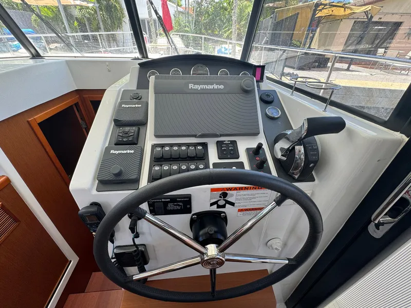 Slide: The Image of 2017 Beneteau Swift Trawler 34 helm with Raymarine navigation system and steering wheel. - 14