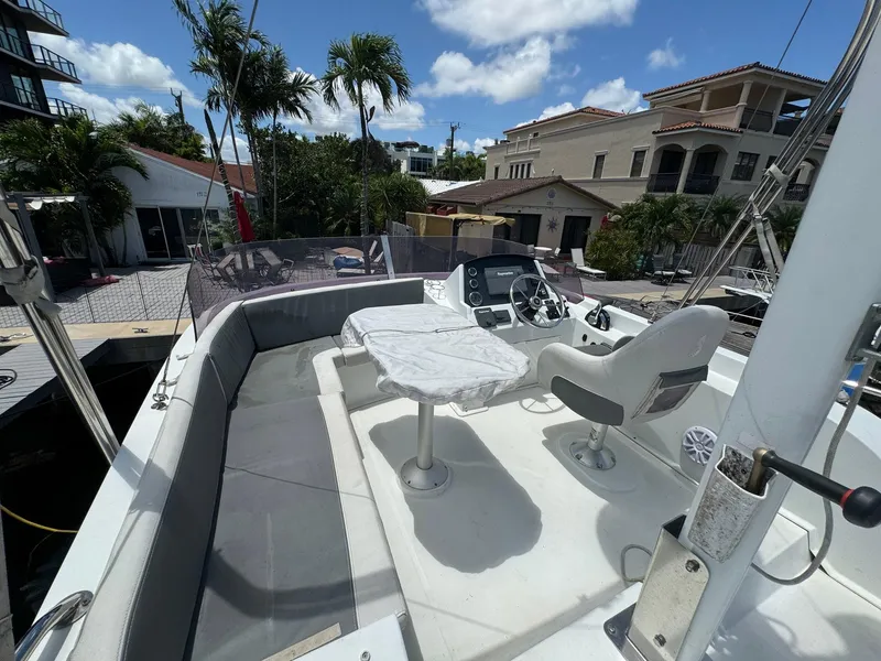 Slide: The Image of 2017 Beneteau Swift Trawler 34 deck with seating and helm, docked near palm trees. - 45