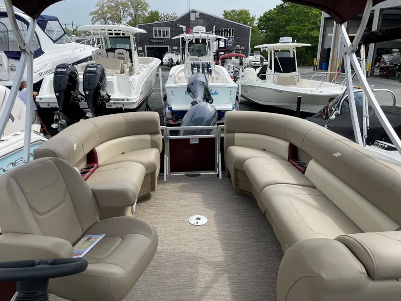 Slide: The Image of 2022 Starcraft LX20R boat interior with beige seating, docked among other boats. - 4