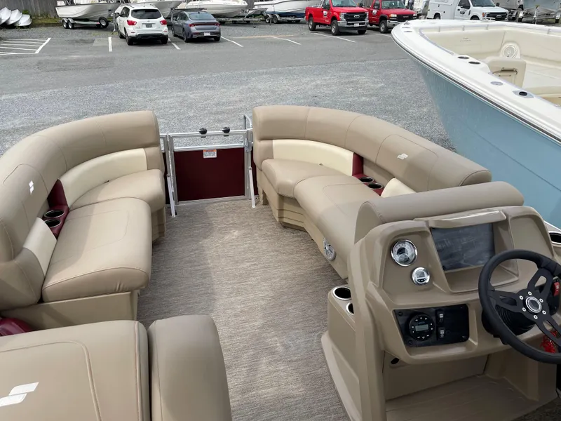 Slide: The Image of 2022 Starcraft LX20R pontoon boat interior with beige seating and modern dashboard. - 5