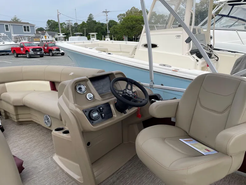 Slide: The Image of 2022 Starcraft LX20R boat interior with beige seating and control panel. - 6