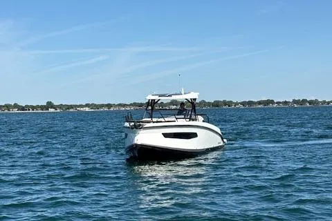 Slide: The Image of Navan C30 2025 boat cruising on a calm lake under a clear blue sky. - 12