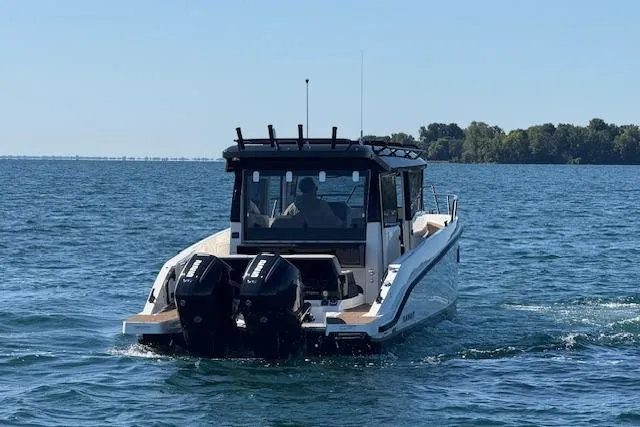 Slide: The Image of Navan C30 2025 boat cruising on a lake with dual outboard motors. - 24
