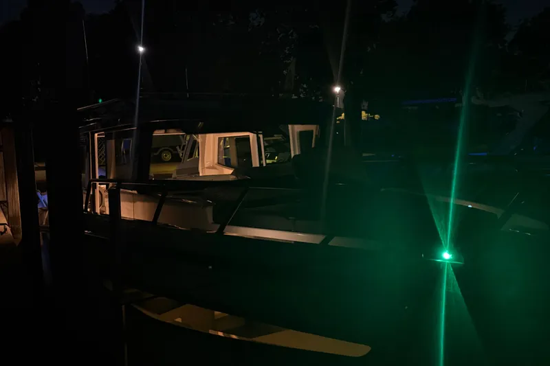 Slide: The Image of 2025 Navan C30 boat illuminated at night with green navigation lights. - 27