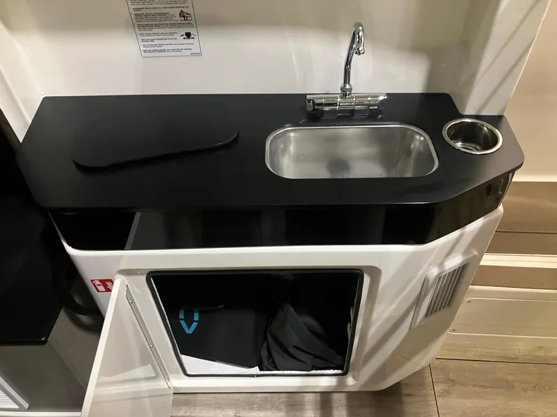 Slide: The Image of Compact kitchen area in a 2025 Navan C30, featuring a sink and storage space. - 7