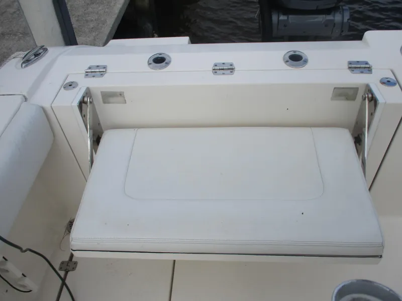 Slide: The Image of 2022 Cobia 237 Center Console boat with fold-down seat and rod holders. - 14