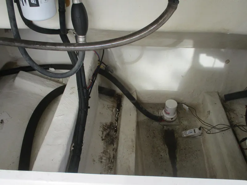 Slide: The Image of Bilge area of 2022 Cobia 237 Center Console boat with hoses and pump. - 16