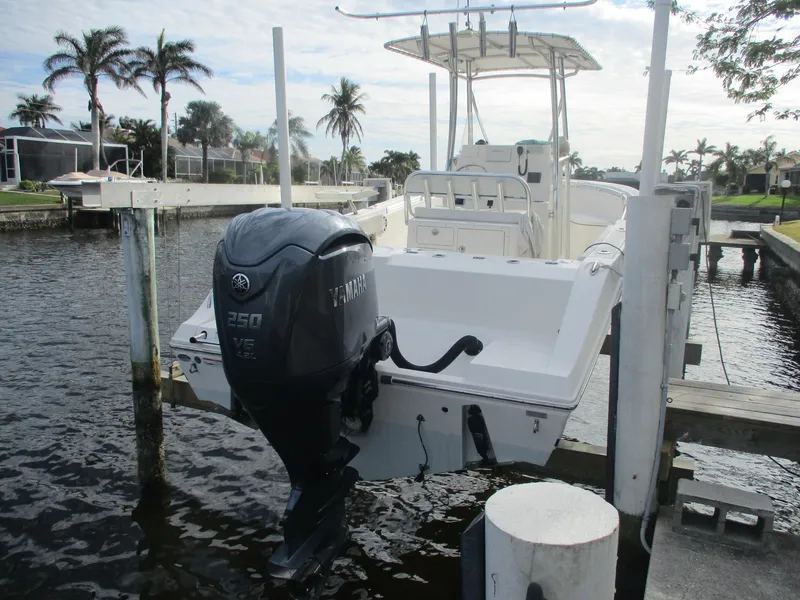 Slide: The Image of 2022 Cobia 237 Center Console boat docked with Yamaha 250 engine, palm trees in background. - 3