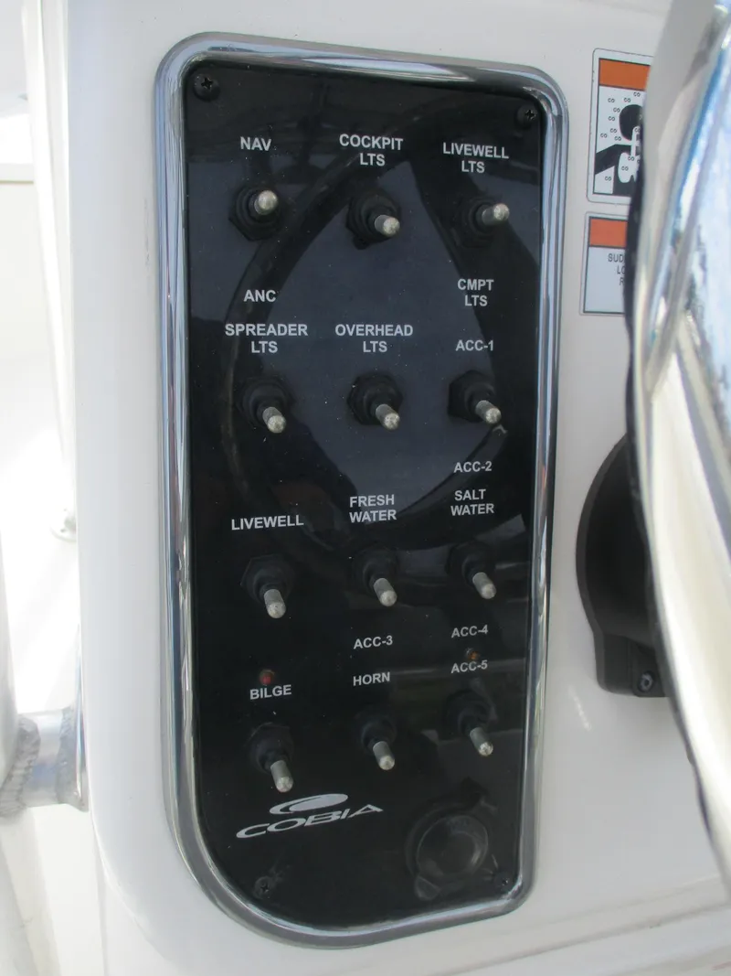 Slide: The Image of Control panel of 2022 Cobia 237 Center Console boat with labeled switches. - 32