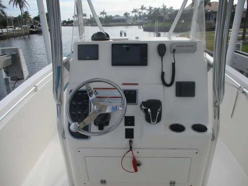 Slide: The Image of 2022 Cobia 237 Center Console boat dashboard with steering wheel and navigation equipment. - 4