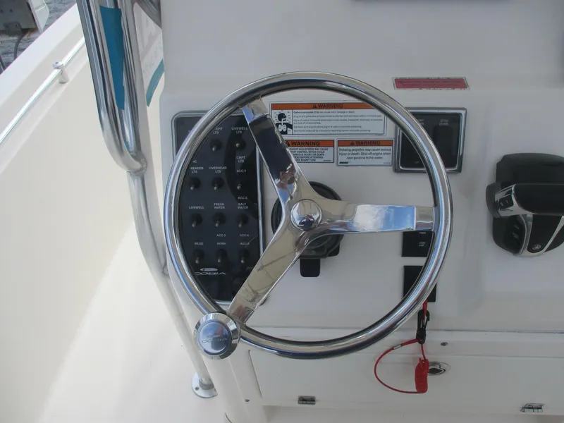 Slide: The Image of Steering wheel of 2022 Cobia 237 Center Console boat with control panel. - 9