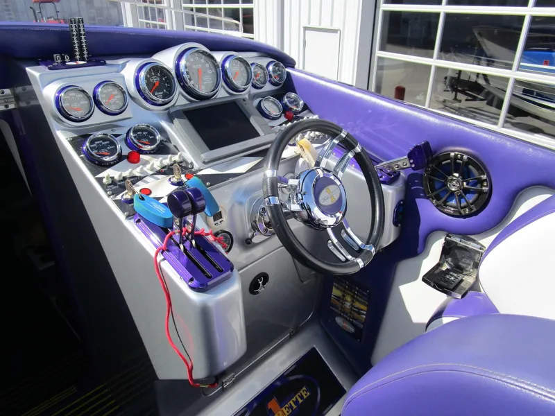 Slide: The Image of 2005 Cigarette 39 Top Gun interior with purple and white seating and audio speakers. - 14