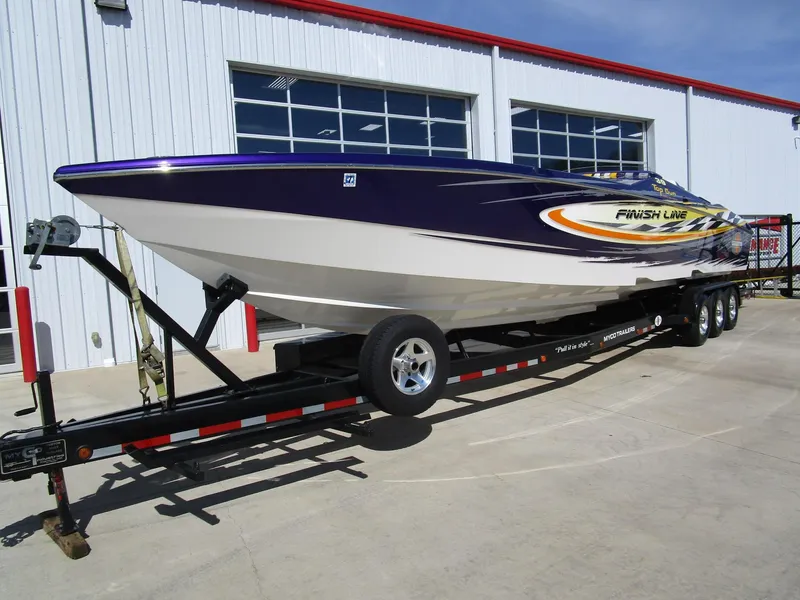 Slide: The Image of 2005 Cigarette 39 Top Gun speedboat with vibrant graphics on a trailer. - 3