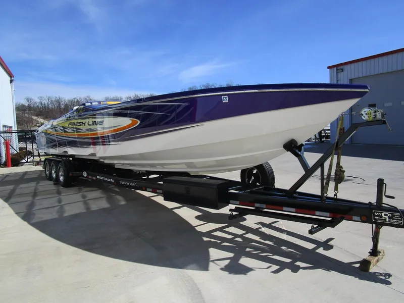 Slide: The Image of 2005 Cigarette 39 Top Gun boat with vibrant yellow and purple design in a marina. - 5