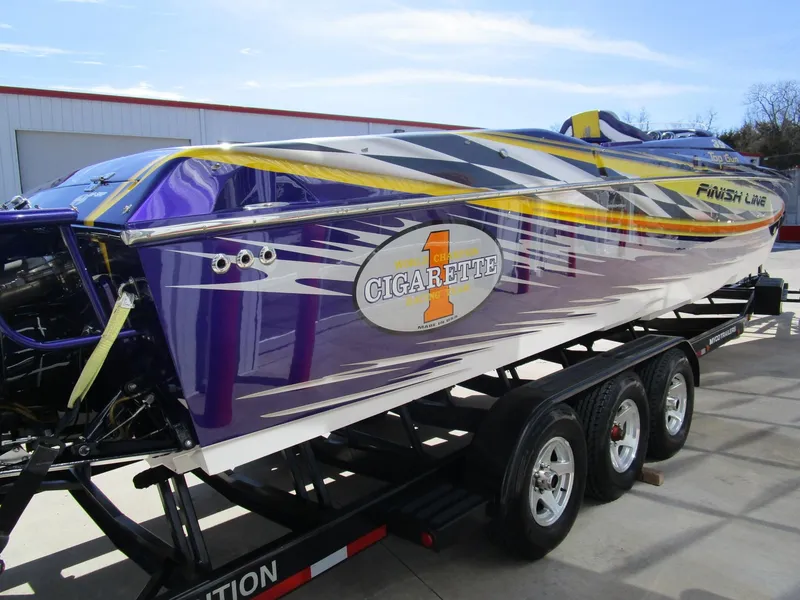 Slide: The Image of 2005 Cigarette 39 Top Gun boat interior with vibrant purple and yellow design, featuring advanced controls. - 7
