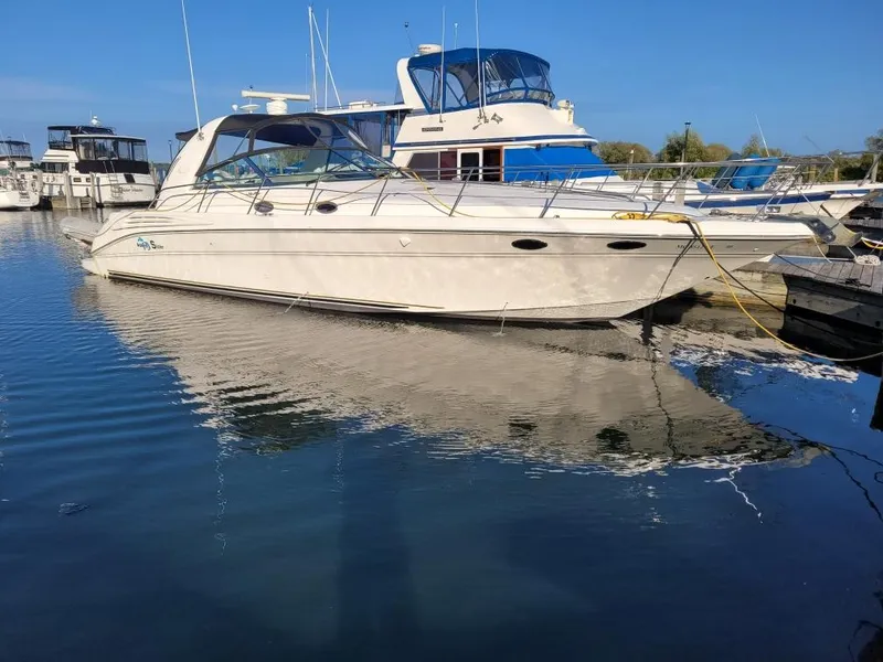 The Image of 1999 Sea Ray Sundancer 400 yacht on calm water under a clear blue sky. - 0