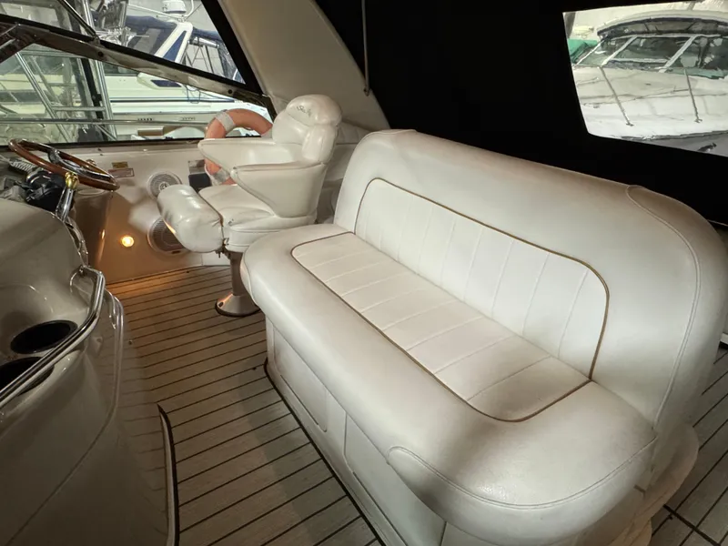 Slide: The Image of 1999 Sea Ray 400 Sundancer helm with steering wheel and navigation controls. - 13