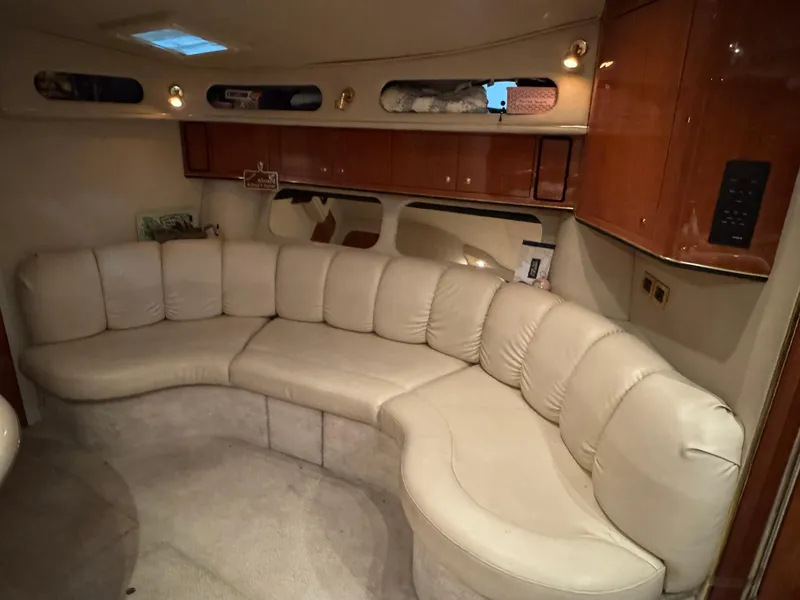 Slide: The Image of Interior of 1999 Sea Ray 400 Sundancer with beige leather seating and wooden cabinetry. - 17