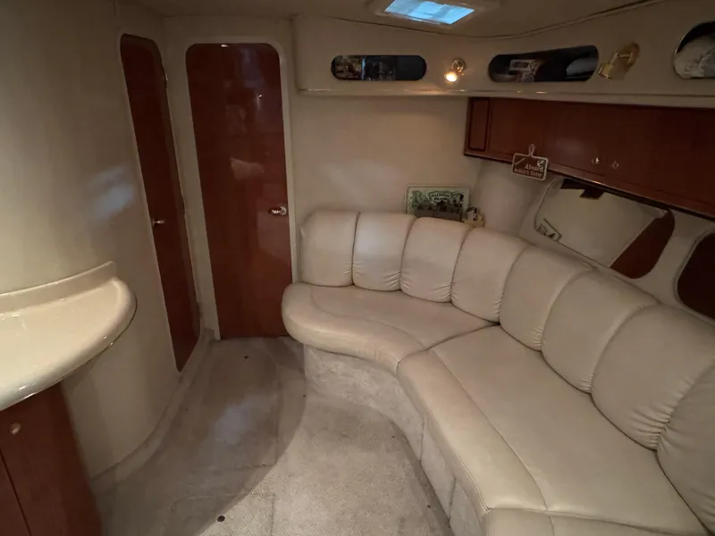 Slide: The Image of 1999 Sea Ray 400 Sundancer cabin interior with beige leather seating and decorative pillow. - 18