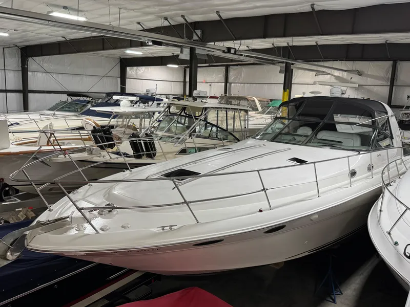 Slide: The Image of 1999 Sea Ray 400 Sundancer yacht in indoor storage, surrounded by other boats. - 2