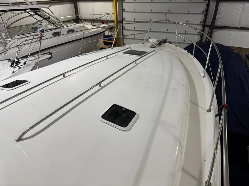 Slide: The Image of 1999 Sea Ray 400 Sundancer boat bow in storage, featuring stainless steel railings. - 28
