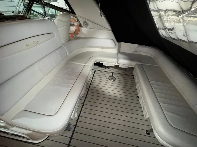 Slide: The Image of 1999 Sea Ray 400 Sundancer interior with white seating and wooden flooring. - 6