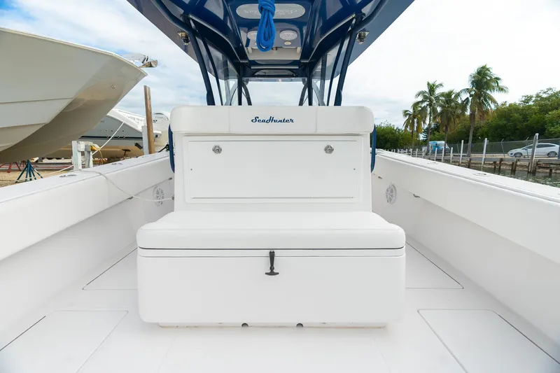 Slide: The Image of 2019 SeaHunter 35 Tournament boat interior with seating, white deck, and palm trees in background. - 14
