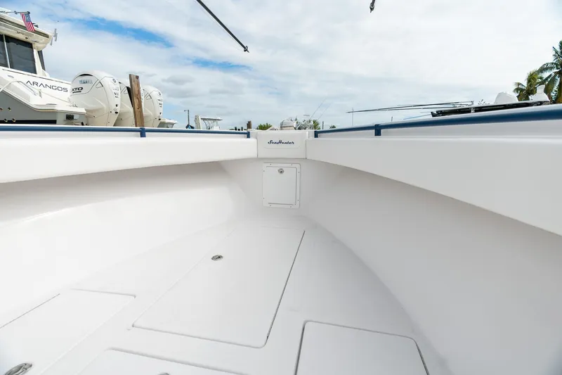 Slide: The Image of 2019 SeaHunter 35 Tournament boat interior, showcasing spacious deck and sleek design under a cloudy sky. - 9