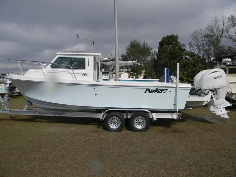 Slide: The Image of 2025 Parker 2420 Sport Cabin boat on trailer, side view, outdoors. - 10