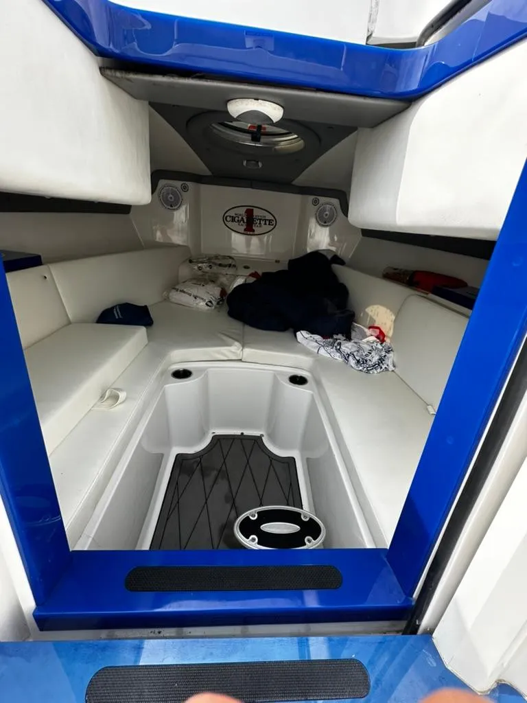Slide: The Image of Interior cabin of a 2011 Cigarette 39 TOP FISH boat, featuring white seating and blue accents. - 7