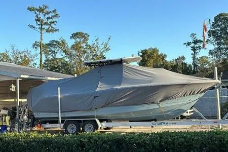The Image of 2022 Sea Hunt Gamefish 27 boat covered on trailer, parked outdoors. - 0