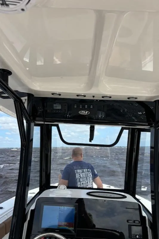 Slide: The Image of 2022 Sea Hunt Gamefish 27 boat interior with person navigating on open water. - 5