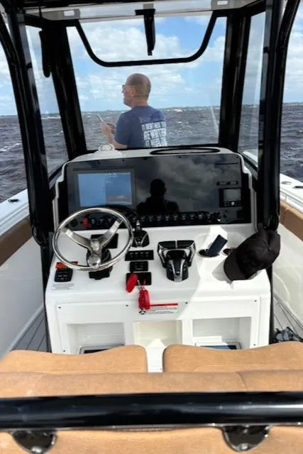 Slide: The Image of 2022 Sea Hunt Gamefish 27 Forward Seating boat interior with steering console and ocean view. - 6
