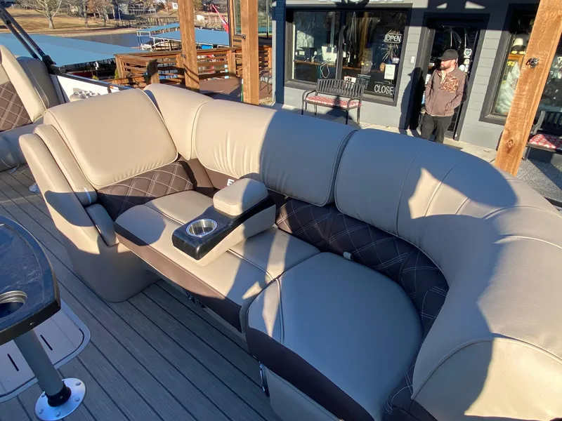 Slide: The Image of Luxurious seating on 2025 SunCatcher Elite 324 SS boat, featuring beige upholstery and cup holder. - 11