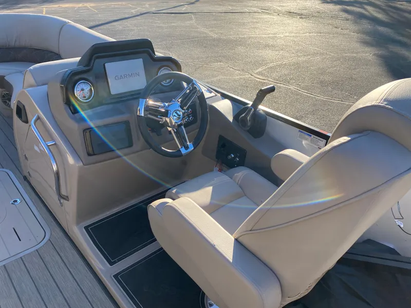 Slide: The Image of 2025 SunCatcher Elite 324 SS boat interior with steering wheel and Garmin display. - 16