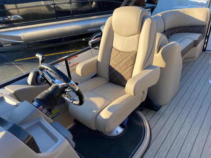 Slide: The Image of 2025 SunCatcher Elite 324 SS boat interior with luxurious seating and steering wheel. - 18