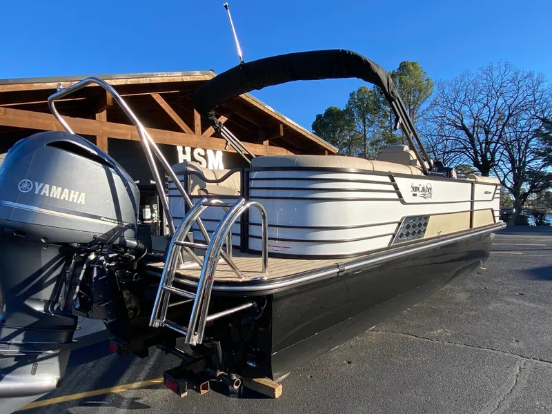 Slide: The Image of 2025 SunCatcher Elite 324 SS pontoon boat with Yamaha motor, docked outdoors. - 2