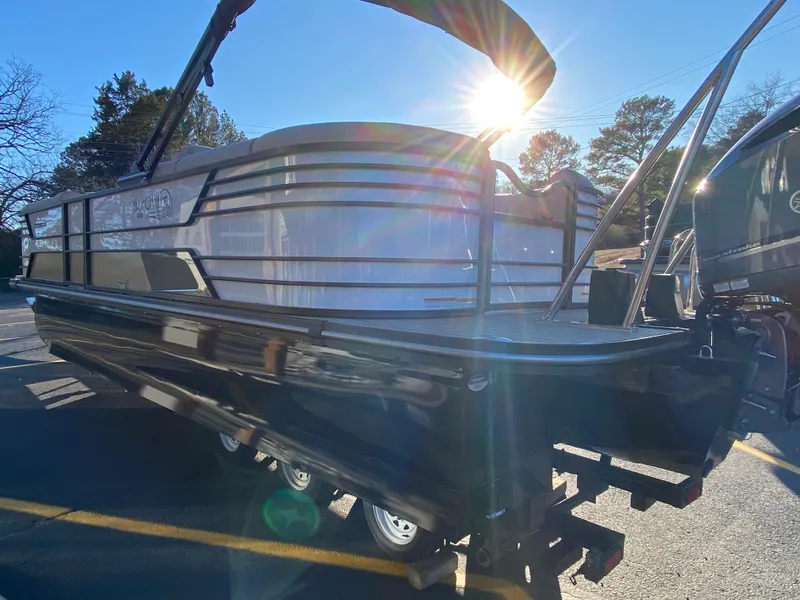 Slide: The Image of 2025 SunCatcher Elite 324 SS pontoon boat in sunlight, side view. - 3
