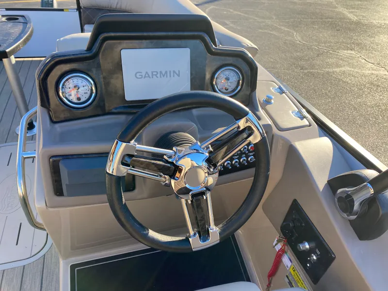 Slide: The Image of 2025 SunCatcher Elite 324 SS boat dashboard with Garmin navigation system and steering wheel. - 7