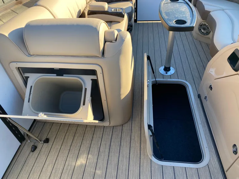 Slide: The Image of 2025 SunCatcher Elite 324 SS interior with storage compartments and seating. - 9