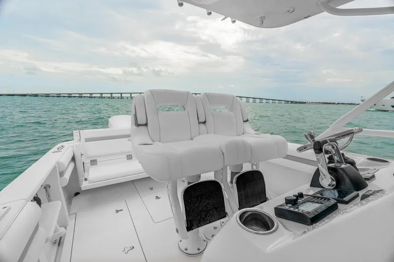 Slide: The Image of 2014 Intrepid 327 Cuddy boat interior with helm and seating, ocean view. - 14
