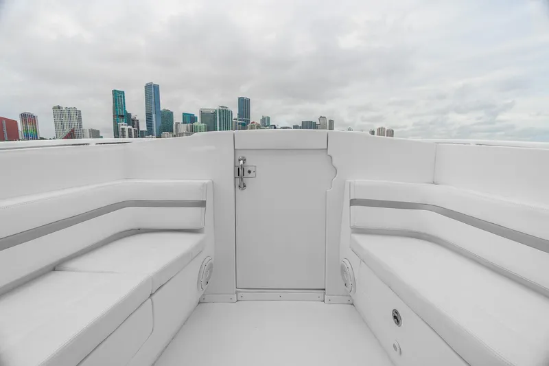 Slide: The Image of 2014 Intrepid 327 Cuddy boat interior with city skyline in the background. - 16