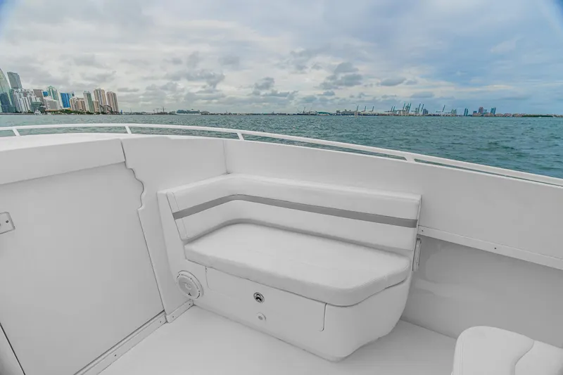 Slide: The Image of 2014 Intrepid 327 Cuddy boat interior with ocean view and city skyline. - 17