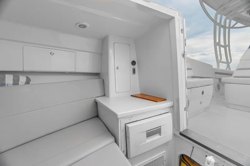 Slide: The Image of 2014 Intrepid 327 Cuddy interior with seating and storage compartments. - 19