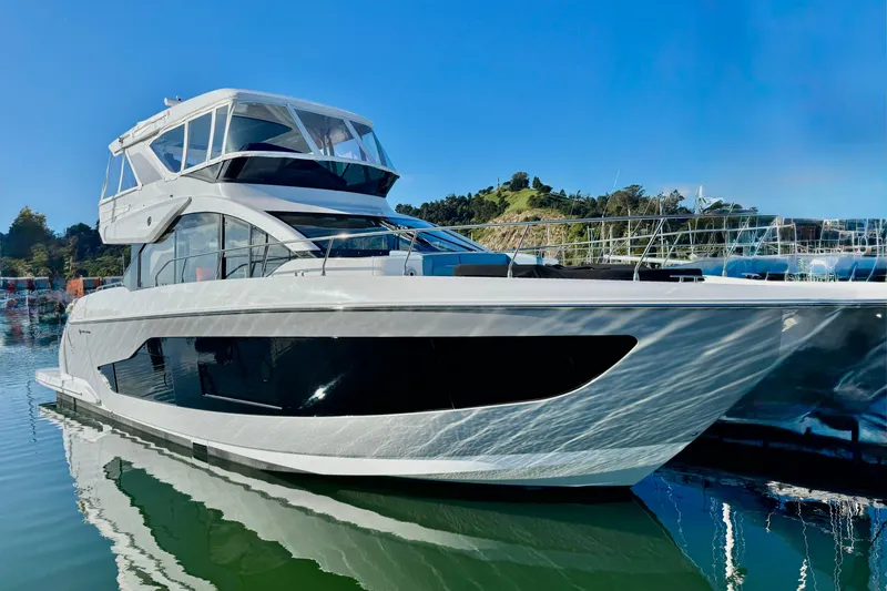 The Image of 2026 Cruisers Yachts 57 Fly luxury yacht on calm water, clear blue sky. - 0